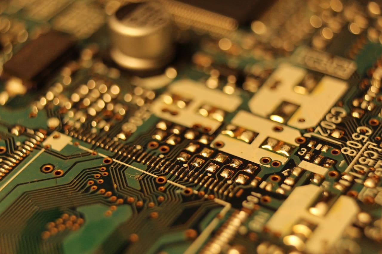 Macro photo of gold-toned circuit board components and solder points