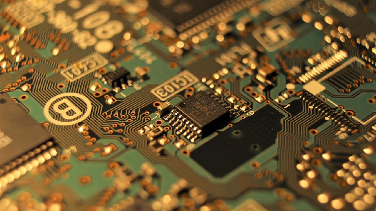 Close-up of a green circuit board with integrated chips and etched traces